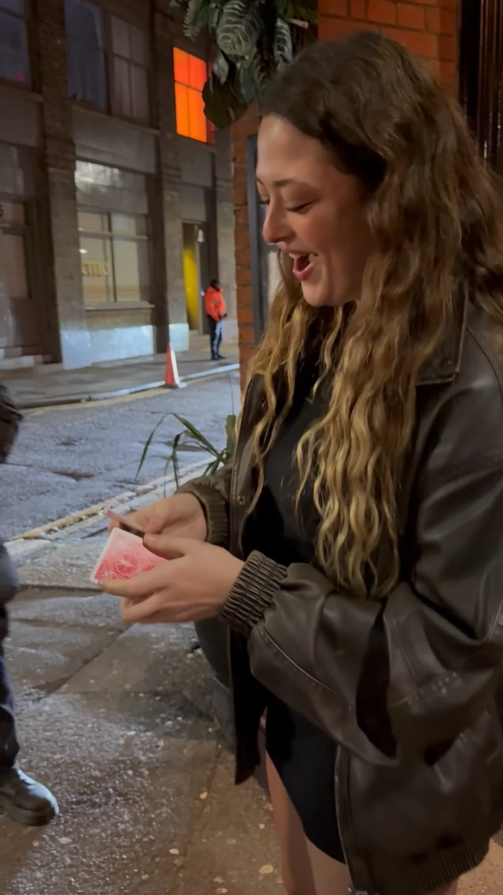 A guest smiling as she reacts to Shane Joseph's close-up card magic